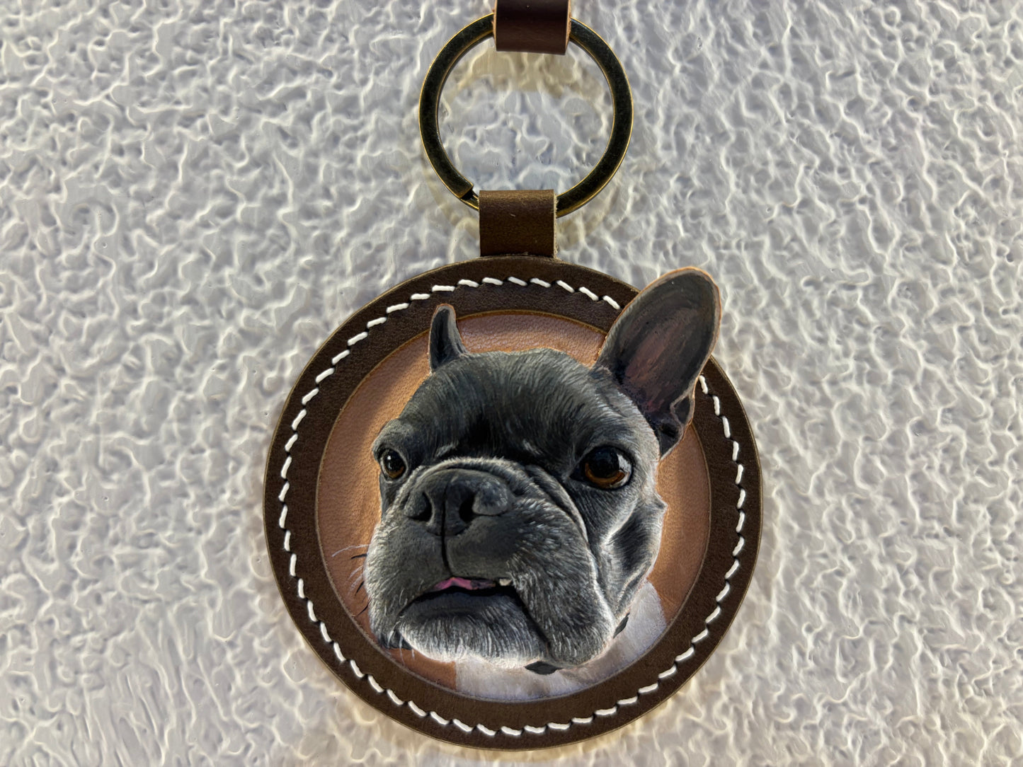 Custom French bulldog portrait leather keychain on a textured white background